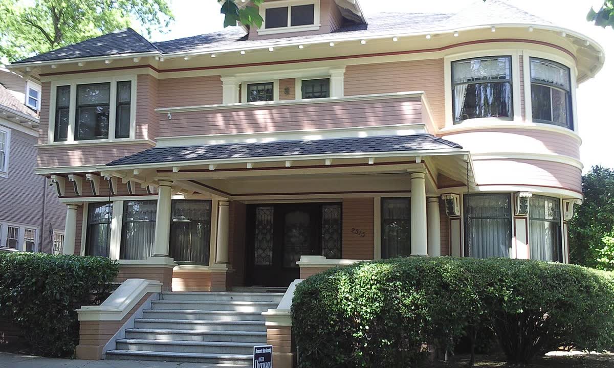Two-story stucco house with a hip roof and front steps in East Sacramento