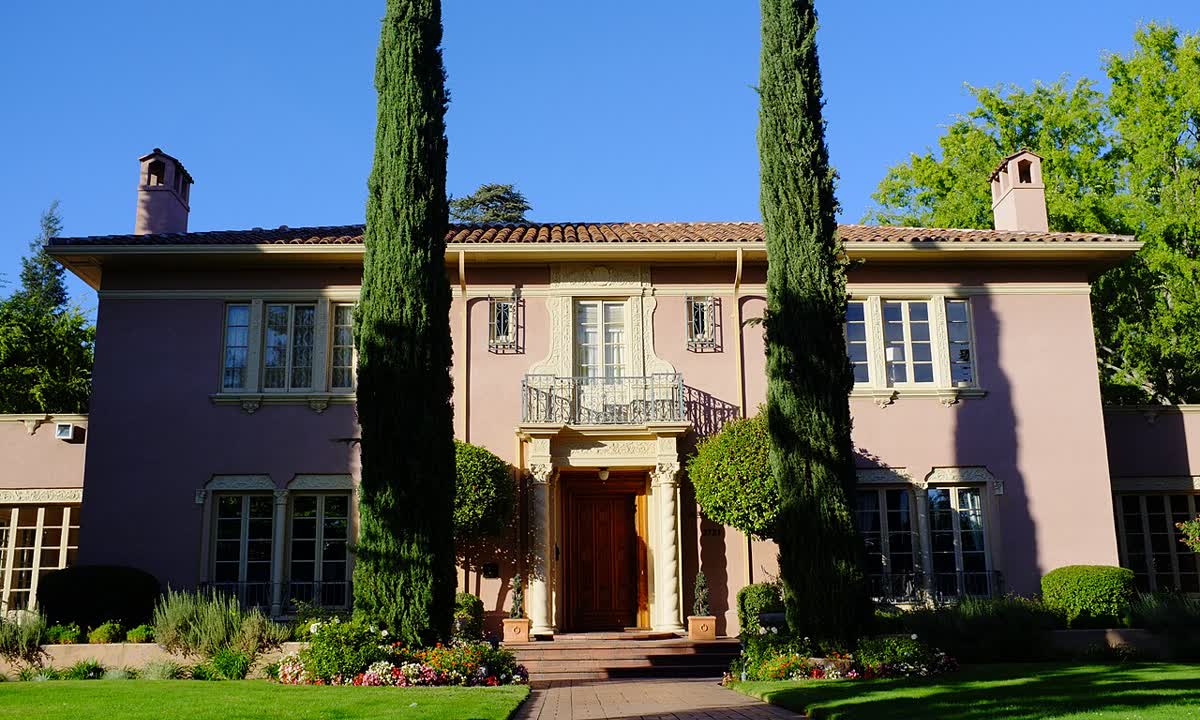 The Julia Morgan House, a large Mediterranean-style home behind cypress trees on T Street