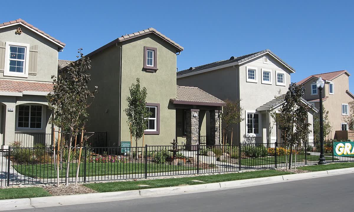 Row of new two-story model homes with small front yards in Sacramento